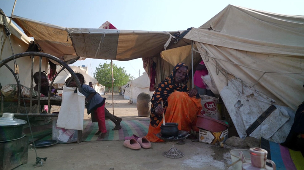 A woman prepares food in a displaced persons camp in Sudan.
